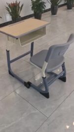Primary and middle school students lifting desks and chair - Image 2